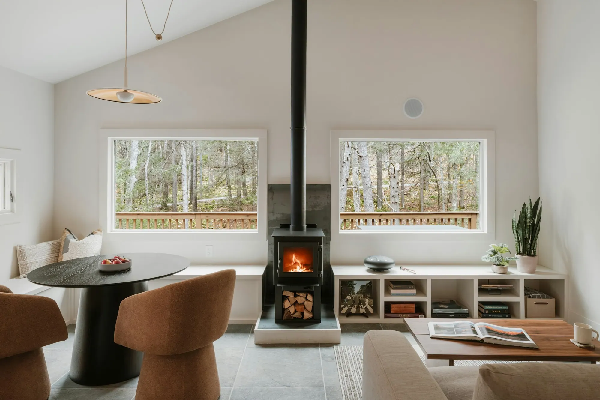 Séjour raffiné avec cheminée et vastes ouvertures, ambiance éditoriale.